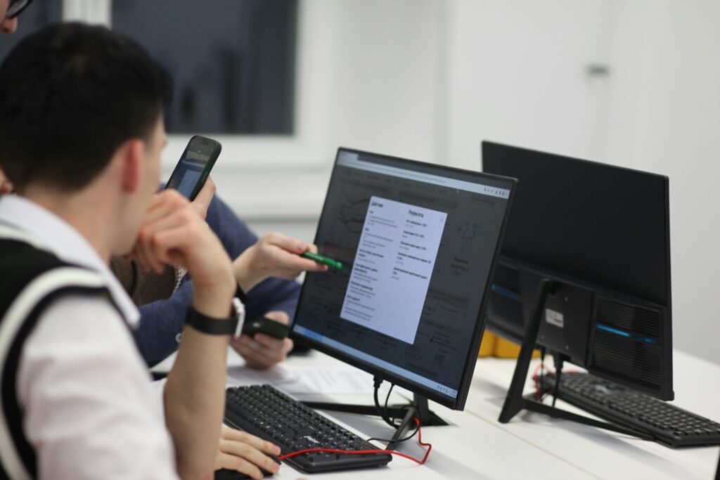 2 students in observing a computer screen whilst in conversation